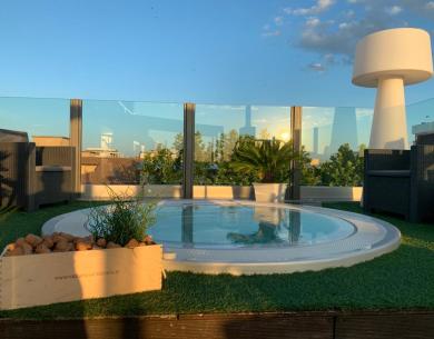 Terrasse mit Whirlpool und Panoramablick bei Sonnenuntergang.