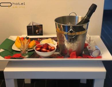 Champagne avec fruits et pétales de rose sur une table d'hôtel.