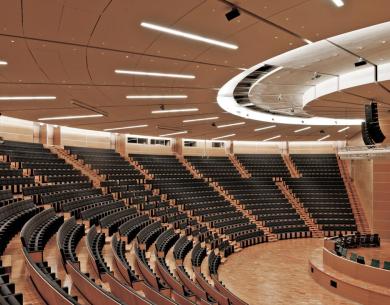 Auditorium moderno con sedili neri e illuminazione elegante.