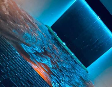 Cascade d'eau illuminée avec des lumières bleues dans un spa moderne.