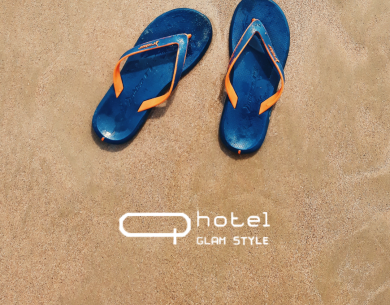 Infradito blu sulla sabbia con logo hotel.