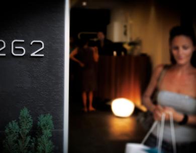 Ingresso con numero 262, persone sfocate sullo sfondo.