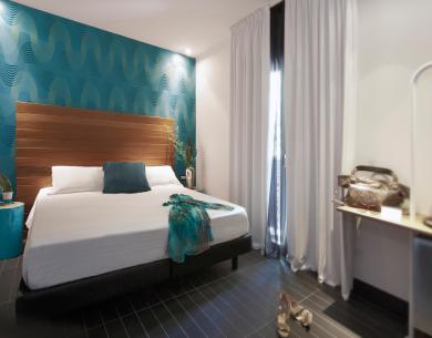 Chambre moderne avec lit double et décorations bleues.