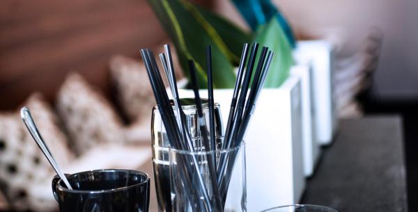 Tavolo da caffè con tazze, cannucce e decorazioni moderne.