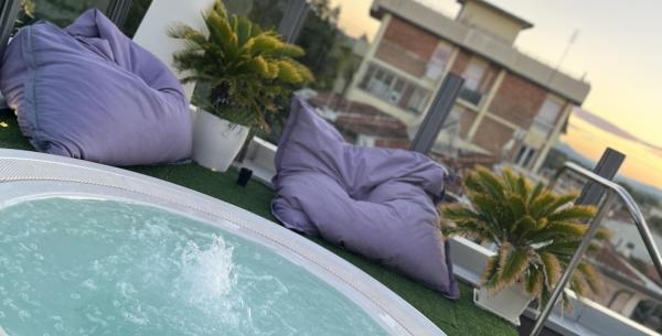 Jacuzzi sur le toit avec fruits et champagne au coucher du soleil.