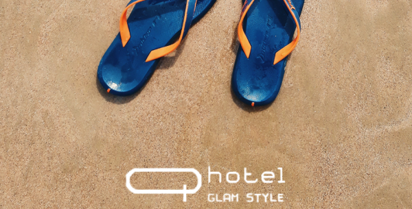 Infradito blu sulla sabbia con logo hotel.