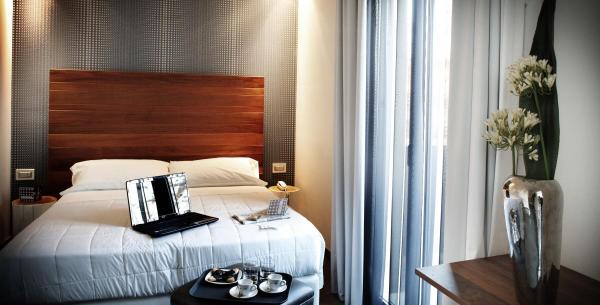 Chambre moderne avec lit, ordinateur portable et plateau café.