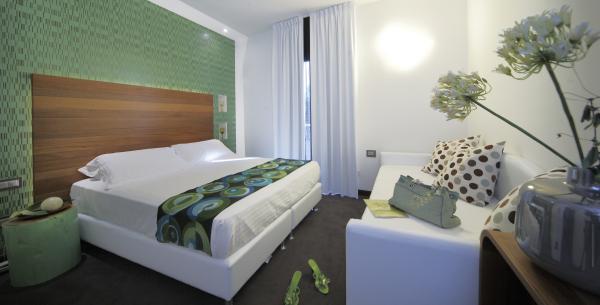 Camera moderna con letto matrimoniale e decorazioni verdi.