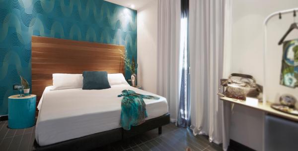 Chambre moderne avec lit double et décorations bleues.